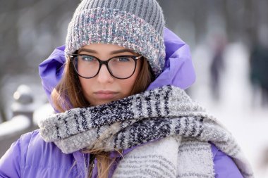  Kış parkında yürüyüş yapmak için kalın elbiseli güzel bir kız..