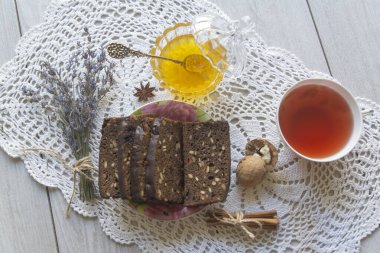 Ballı tatil kurtarıldı. Masada bal, siyah ekmek ve çay var..