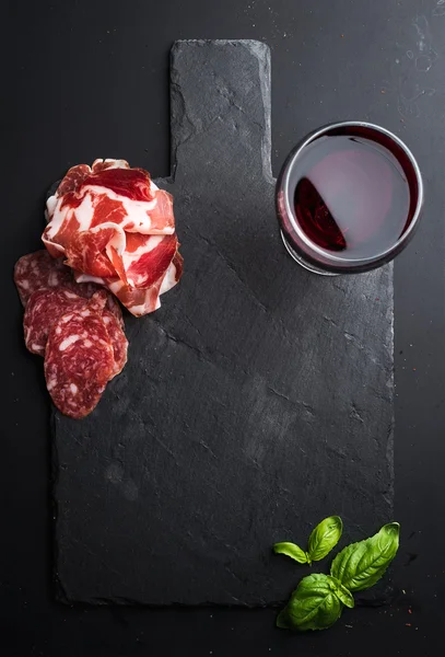 Copo de vinho tinto, aperitivo de carne e manjericão — Fotografia de Stock