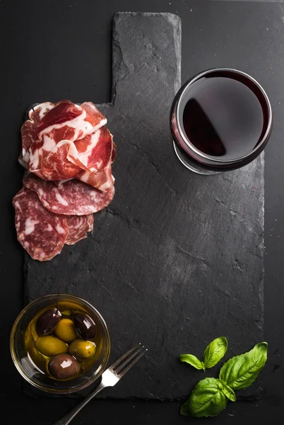 Glass of red wine, meat appetizer