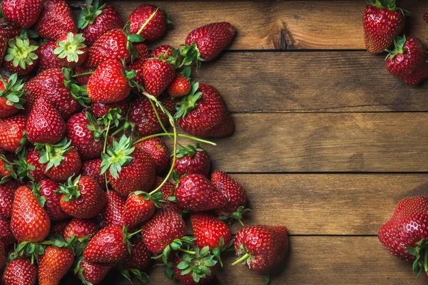 Strawberries over natural wooden background — Stock Photo, Image