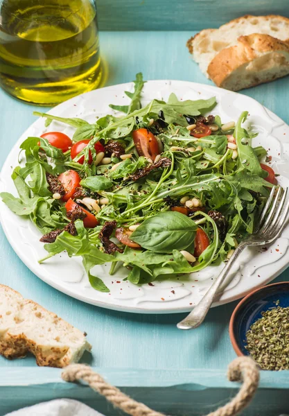 Ensalada con rúcula, tomates cherry, piñones y hierbas —  Fotos de Stock