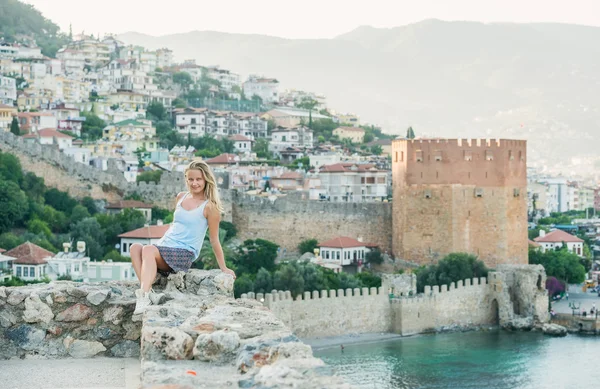 Donna bionda seduta su un antico muro della fortezza — Foto Stock