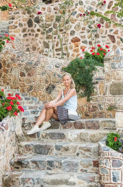 Giovane donna seduta su antiche scale — Foto Stock