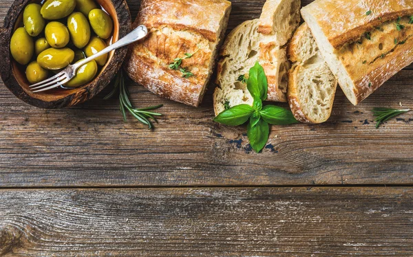 Red wine glass, green olives and ciabatta — Stock Photo, Image