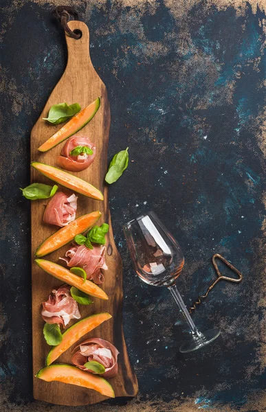 Prosciutto, cantaloupe melon and wine glass — Stock Photo, Image