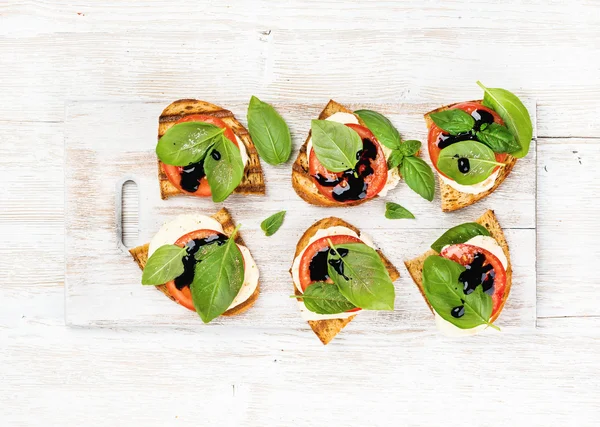 Sandvișuri caprese cu roșii, brânză mozzarella, busuioc — Fotografie, imagine de stoc