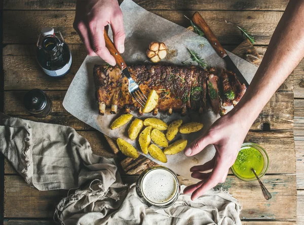 Mann isst gebratene Schweinerippchen — Stockfoto