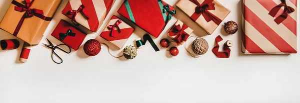 お祝いBeije 緑と赤の色の工芸品のギフトボックスのフラットレイアウト 紙を包む プレーンホワイトの背景 トップビュー コピースペース上に大胆な影を持つカラフルなボールやリボン クリスマス休暇トレンディーなグリーティングカードやバナー クリスマスボクシングの日 — ストック写真