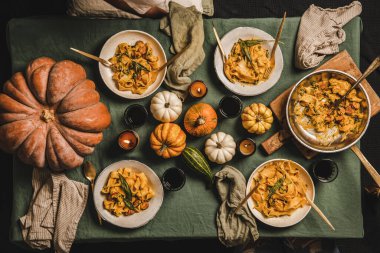 Toplanma ya da Şükran Günü kutlama partisi için Autumn Flat-lay yemeği. Sosisli kabak ezmeli makarna ve tabakta adaçayı ve keten masa örtüsünün üzerinde kırmızı şarap.