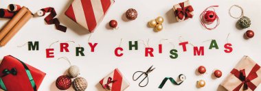 Ağaç süsleme mektupları, bayramlık hediye kutuları, ambalaj kağıtları, takılar, beyaz arka planda kurdeleler, üst manzara. Noel tatili modası tebrik kartı, afiş