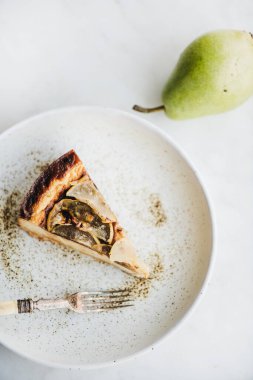 Vejetaryen sütsüz, şekersiz, kırsal tabakta armut peynirli kek ve beyaz mermer masa zemininde taze armut, üst manzara. Modern vejetaryen sağlıklı tatlı konsepti