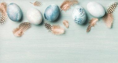 Paskalya için açık mavi arka planda boyanmış yumurtalar