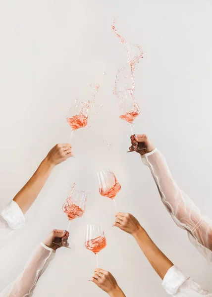 Mãos Femininas Girando Copos Vinho Rosa Fazendo Salpicos Sobre Fundo — Fotografia de Stock