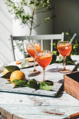 Aperol Spritz aperatif. Bardaklarda taze portakallı soğuk içki. Masadaki gri mermer tahtada buz var. Yaz ferahlatıcı içecek konsepti