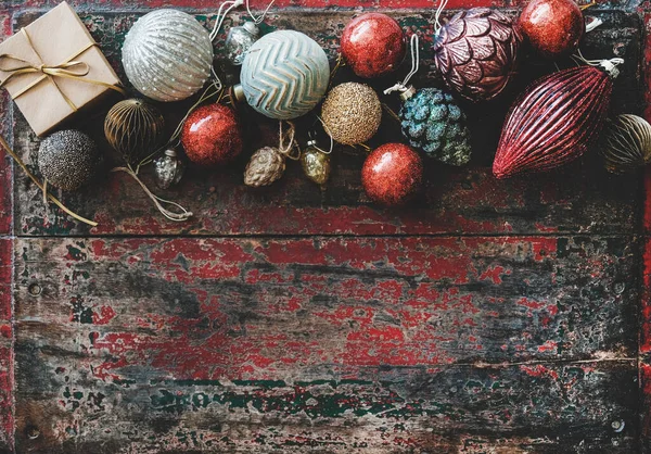 クリスマスや新年の休日の背景 テクスチャ 赤い素朴な木製の背景 トップビュー コピースペースの上にクリスマスのお祝いの装飾のおもちゃやボールのフラットレイ — ストック写真