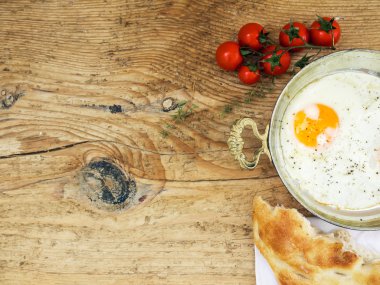 Odaya Servis Kahvaltı Seti: kızarmış yumurta, ekmek ve bir tahta üzerinde domates 