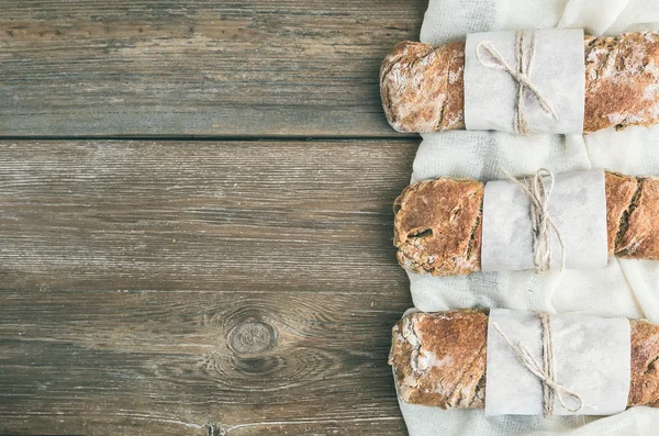 Pan de pueblo rústico recién horneado (baguette) sobre madera rugosa — Foto de Stock