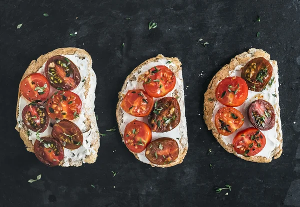 Ricotta ve kiraz domates sandviç üzerinde bir dar taze kekik ile