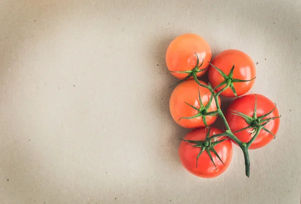 Bos van verse rijpe rode tomaten over een ambachtelijke papier achtergrond w — Stockfoto