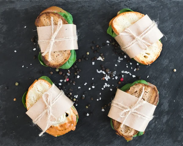 Chicken and spinach sandwiches wrapped in craft paper — Stock Photo, Image