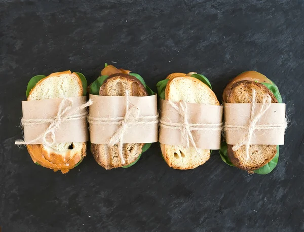 Sanduíches de frango e espinafre embrulhadas em papel artesanal sobre um dar — Fotografia de Stock