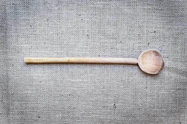 Cuchara de cocción de madera rústica sobre una superficie de saco — Foto de Stock