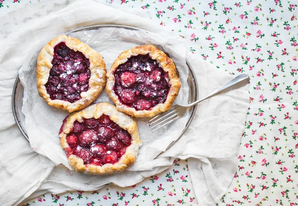 Small rustic berry galettes on silver dish — Stock Photo, Image