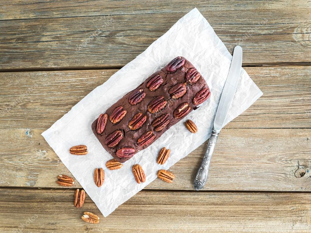 Pecan brownie cake on a wooden background