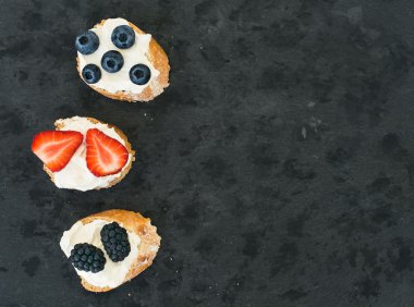 Keçi peyniri ve çilek mini-sandwitches koyu bir taş backgro üzerinde