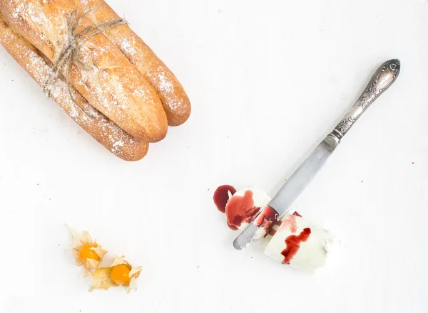 Baguetes recém-assadas, cerejas moídas, um pedaço de queijo de cabra — Fotografia de Stock