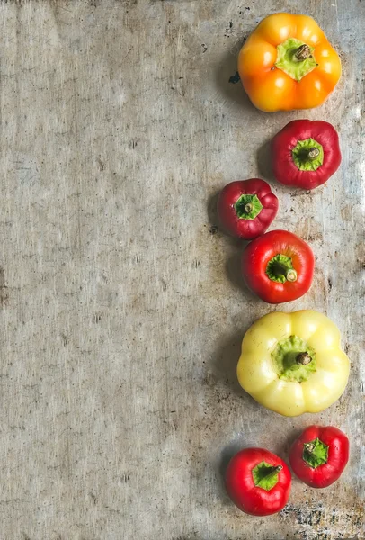 Zoete pepers van verschillende grootte en kleur op rustieke metaal — Stockfoto