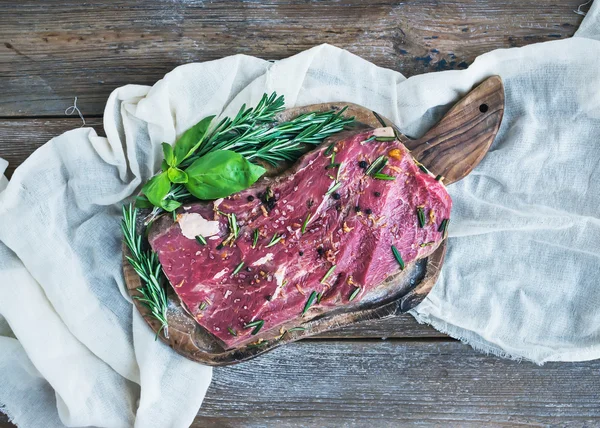 Um pedaço de carne fresca crua (bife Ribeye) marinado em especiarias e — Fotografia de Stock