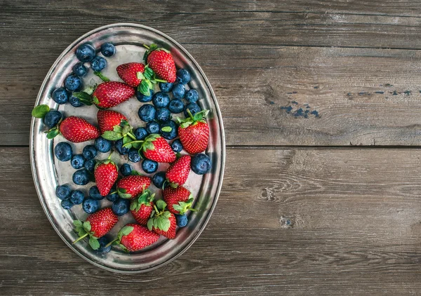 Fresh strawberry and blueberry mix on a metal dish (tray) over a — Stock Photo, Image