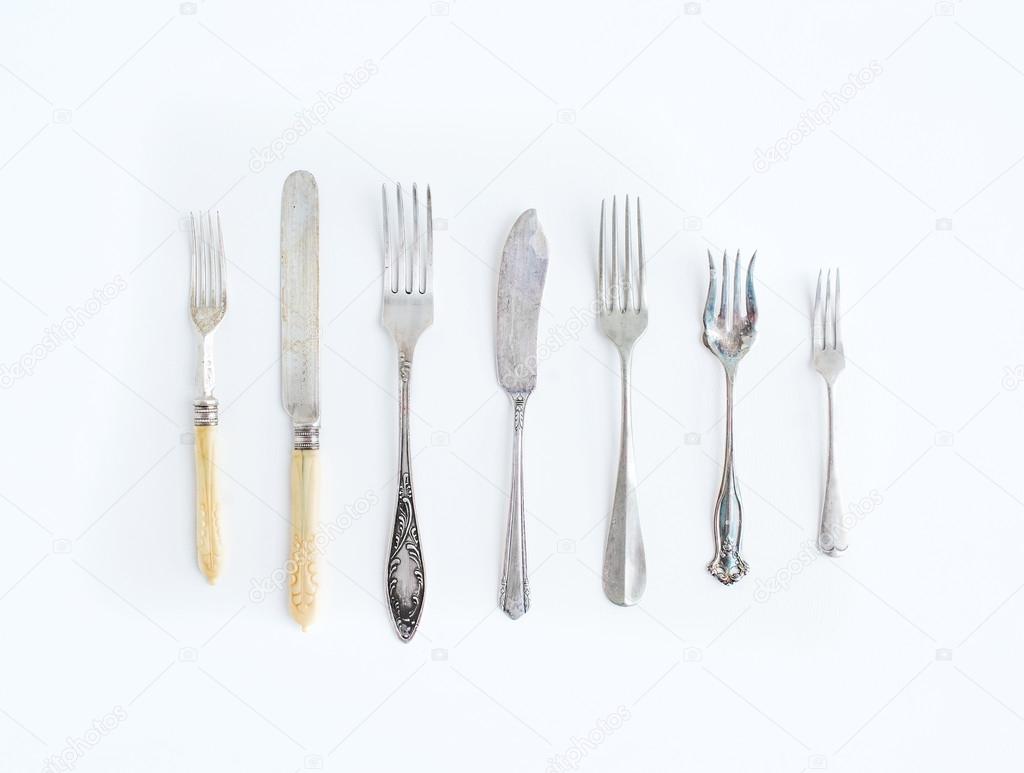 A set of vintage dining knifes and forks of different shapes and