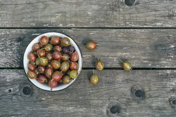 A bawl of gooseberries on a wooden surface — Stock Photo, Image