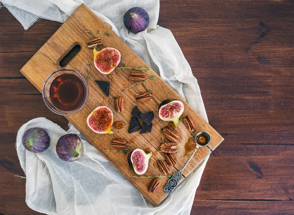 Fresh figs, chocolate and pekan nuts with honey on a wooden boar — Stok fotoğraf