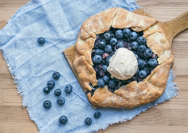 Rustieke blueberry pie op een houten plank en witte weefsel — Stockfoto