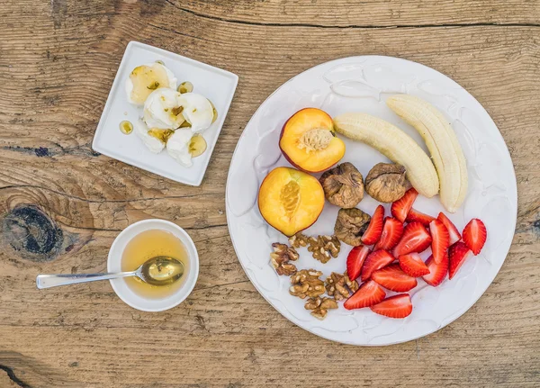 Breakfast set with fresh strawberry, banana, peach, dry figs, wa — Stock Photo, Image