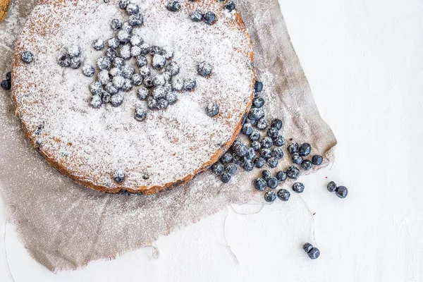 Gâteau aux myrtilles aux myrtilles fraîches et sucre en poudre sur un beig — Photo