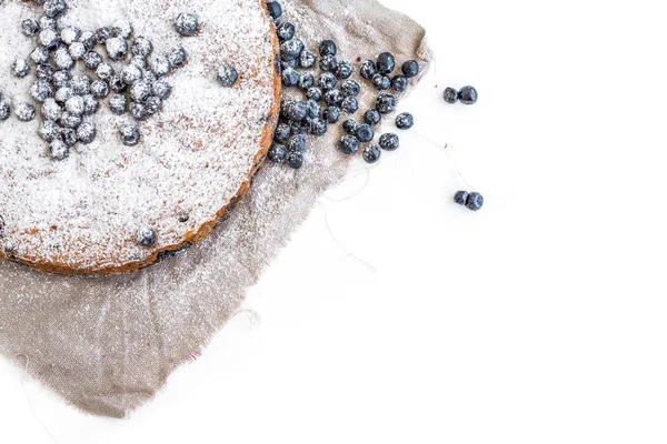 Bolo de mirtilo com mirtilos frescos e açúcar em pó em um bege — Fotografia de Stock