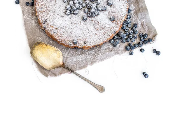 Bolo de mirtilo com mirtilos frescos e açúcar em pó em um bege — Fotografia de Stock