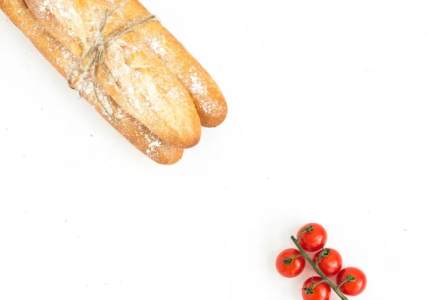 新鲜出炉的法式长棍面包和樱桃西红柿 — 图库照片