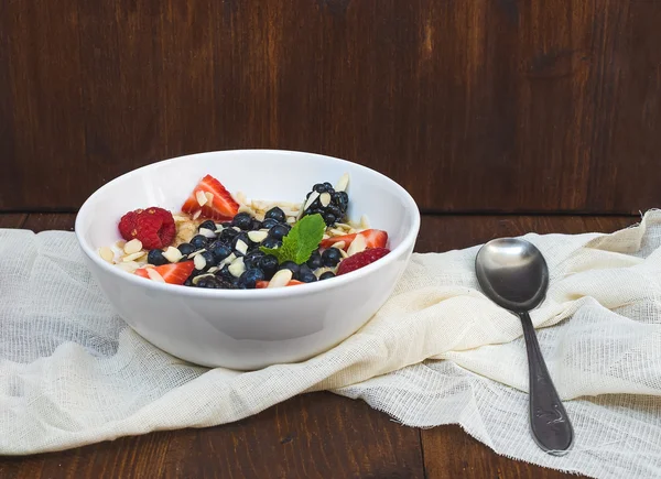 A bawl of oat porridge with fresh berries, honey, almond petals — Stock Photo, Image