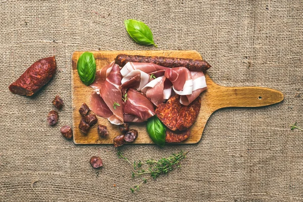 Assiette de viande sur une planche de bois rustique sur un backgroun de sac rugueux — Photo