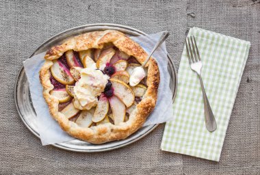 Elma ve berry Galette'ye bir çul yüzey üzerinde metal bir tabak üzerinde