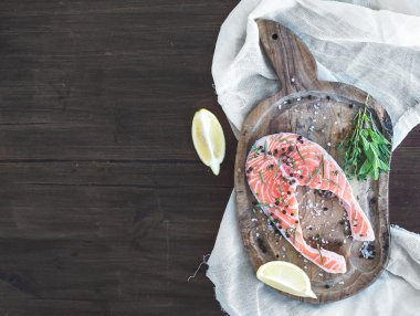 Taze otlar, limon ve baharat rustik wo üzerinde Çiğ somon biftek