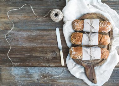 Fırından yeni çıkmış kağıt sarılı rustik Köy ekmeği (baget ekmek) 