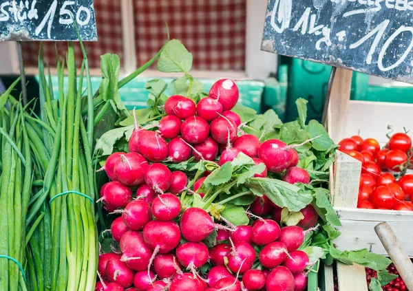 Zahradní ředkvičky a jarní cibulkou na stánku v tržnici — Stock fotografie