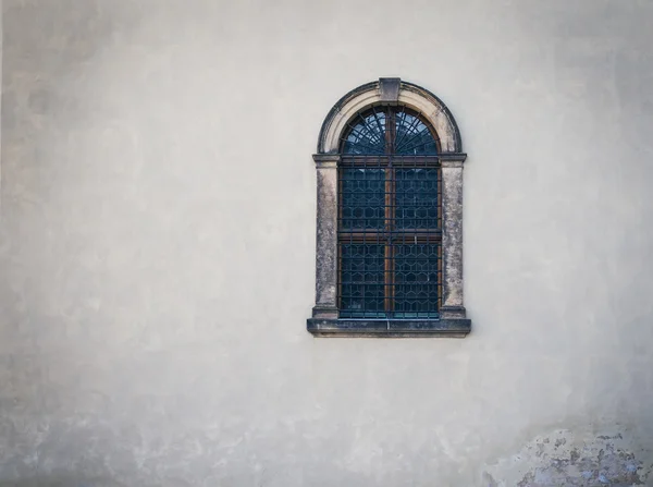Античне середньовічне вікно з залізними брусками і старою білою стіною — стокове фото